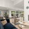 cozy chairs in front of fireplace in well lit clubhouse with kitchen