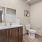 bathroom with toilet sink and large mirror