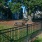 tree shaded gated park area with picnic table and bench