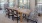 long table surrounded by chairs and windows in resident lounge